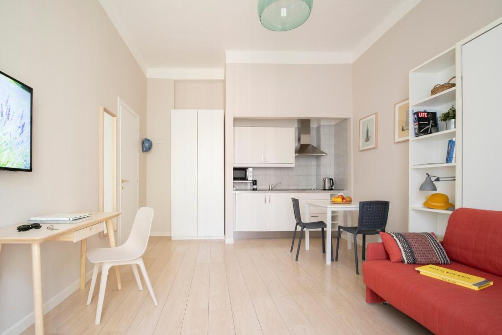 uma sala de estar com um sofá vermelho e uma mesa em Sigieri Residence Milano em Milão