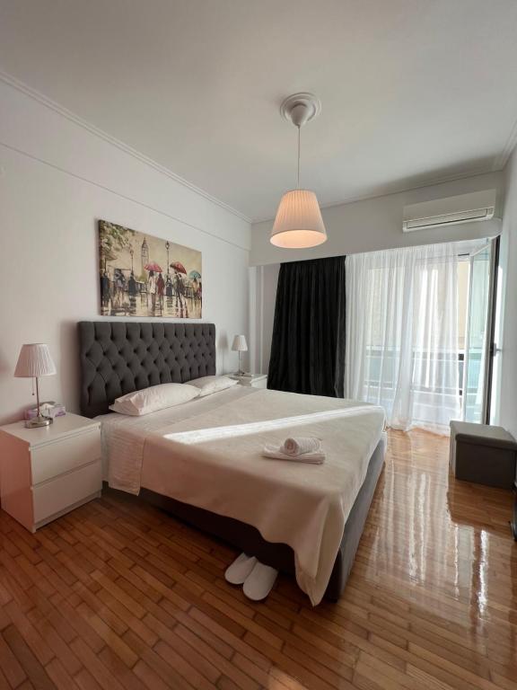 a bedroom with a large bed and a lamp at Modern apartment in the heart of Athens. in Athens