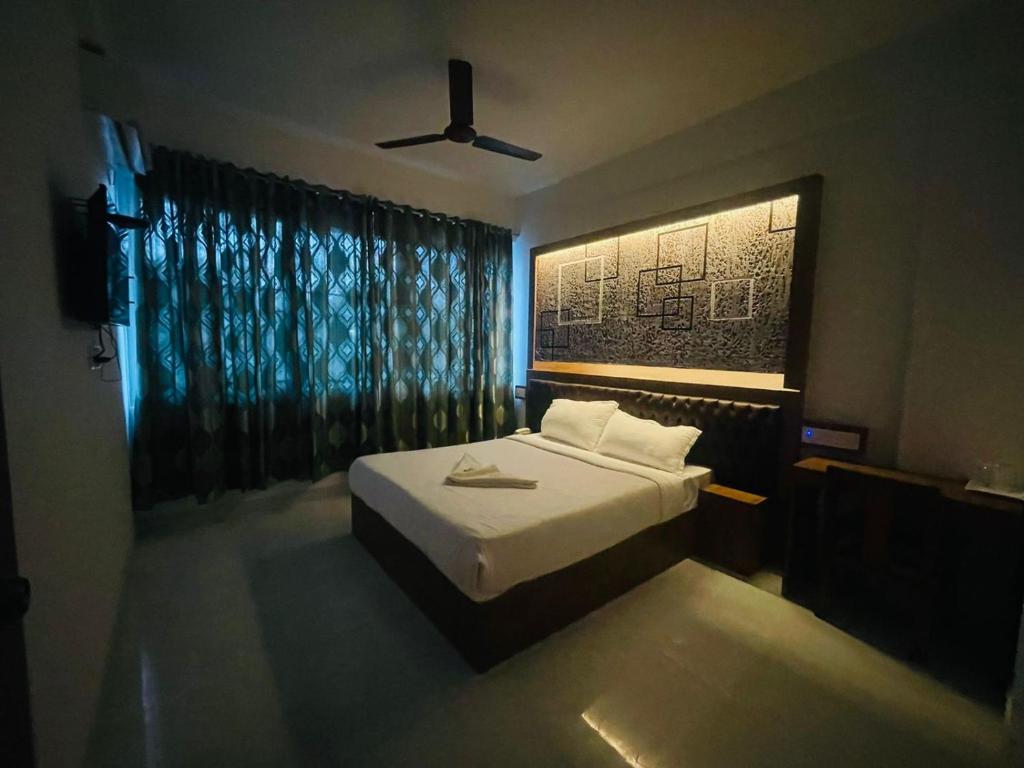 a bedroom with a bed and a ceiling fan at B Six Hotel in Bangalore