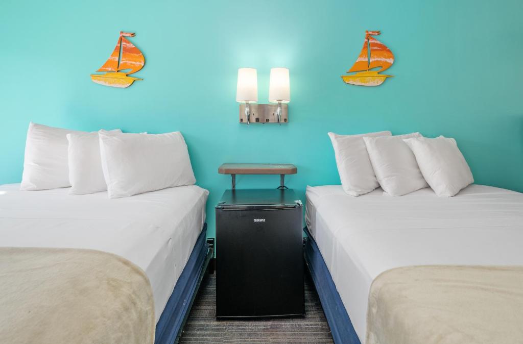 two beds in a room with blue walls at Beach Bum Inn in Ocean City