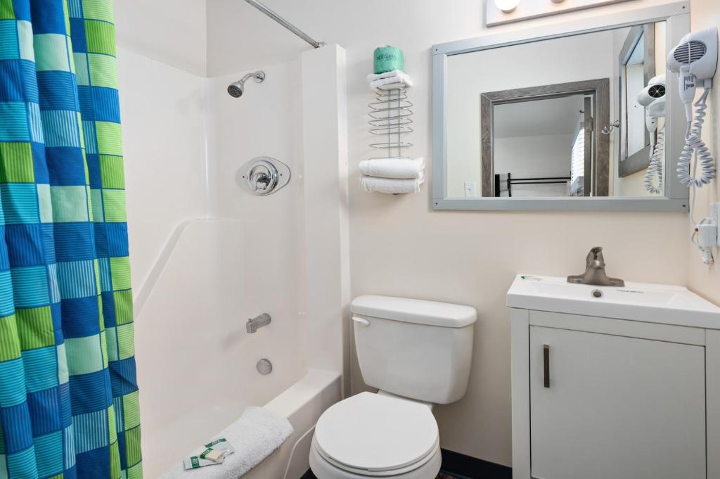 a bathroom with a toilet and a sink and a mirror at Beach Bum Inn in Ocean City