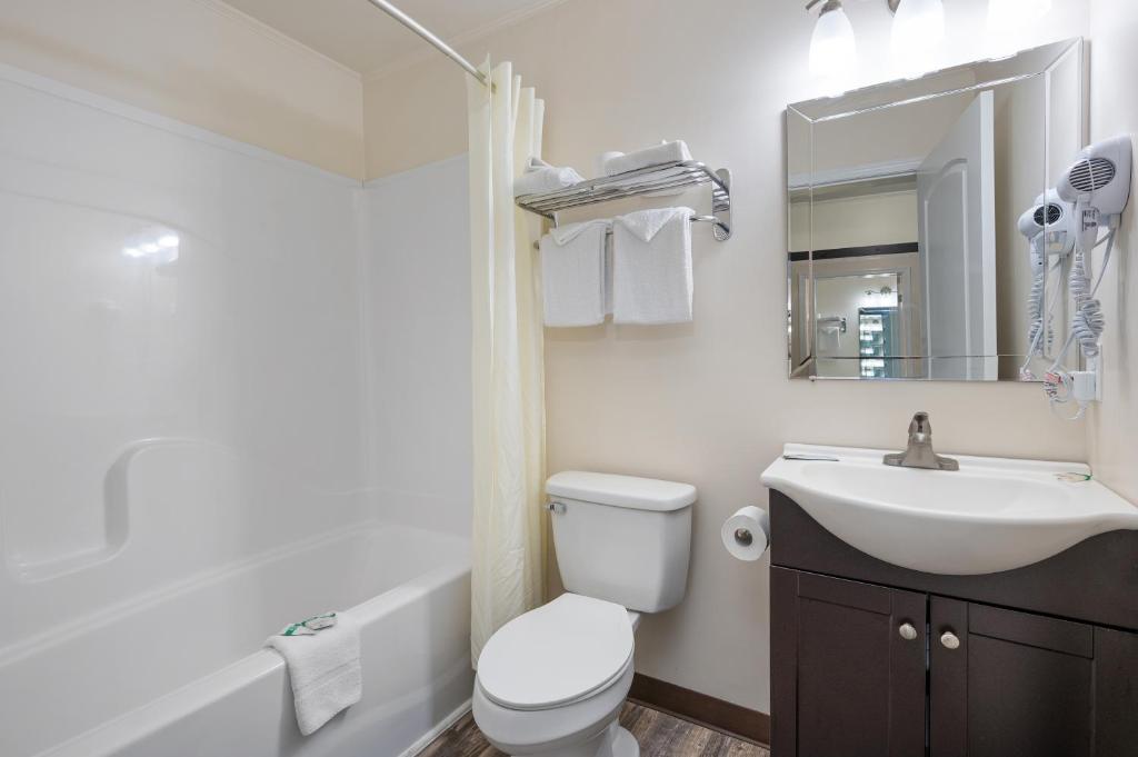 a bathroom with a sink and a toilet and a mirror at Beach Bum Inn in Ocean City