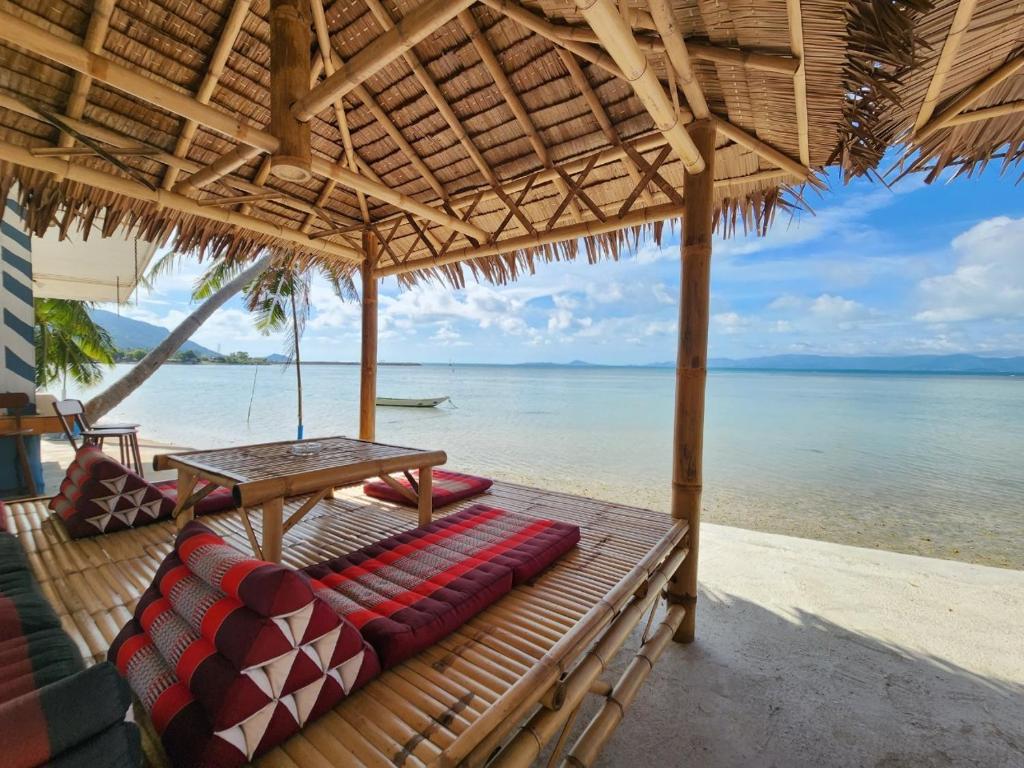 a hammock on a beach with a view of the water at BeauBo Beach in Ban Tai