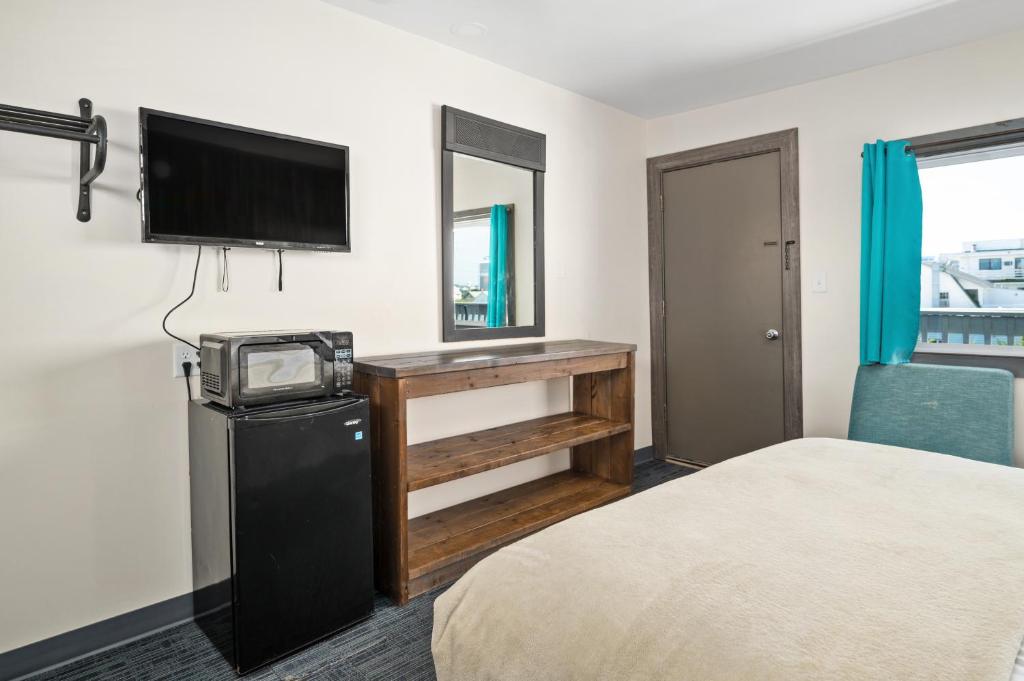 a hotel room with a bed and a flat screen tv at Beach Bum Inn in Ocean City