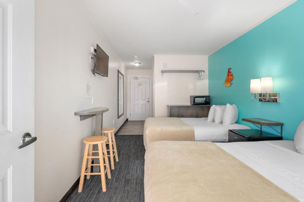 a hotel room with two beds and a stool at Beach Bum Inn in Ocean City