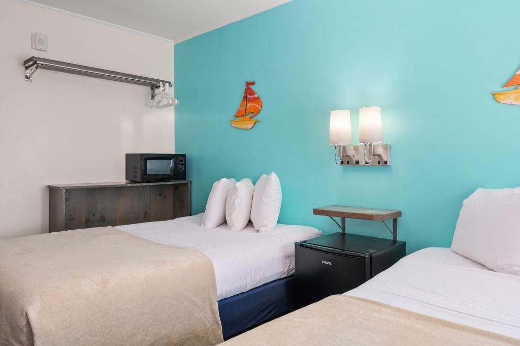 two beds in a room with blue walls at Beach Bum Inn in Ocean City