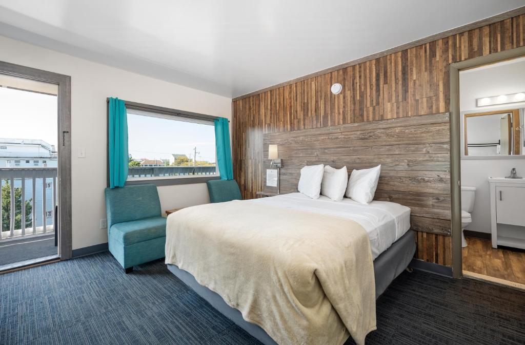 a hotel room with a bed and a blue chair at Beach Bum Inn in Ocean City