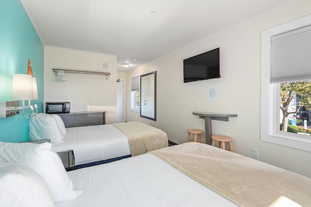 a hotel room with two beds and a television at Beach Bum Inn in Ocean City