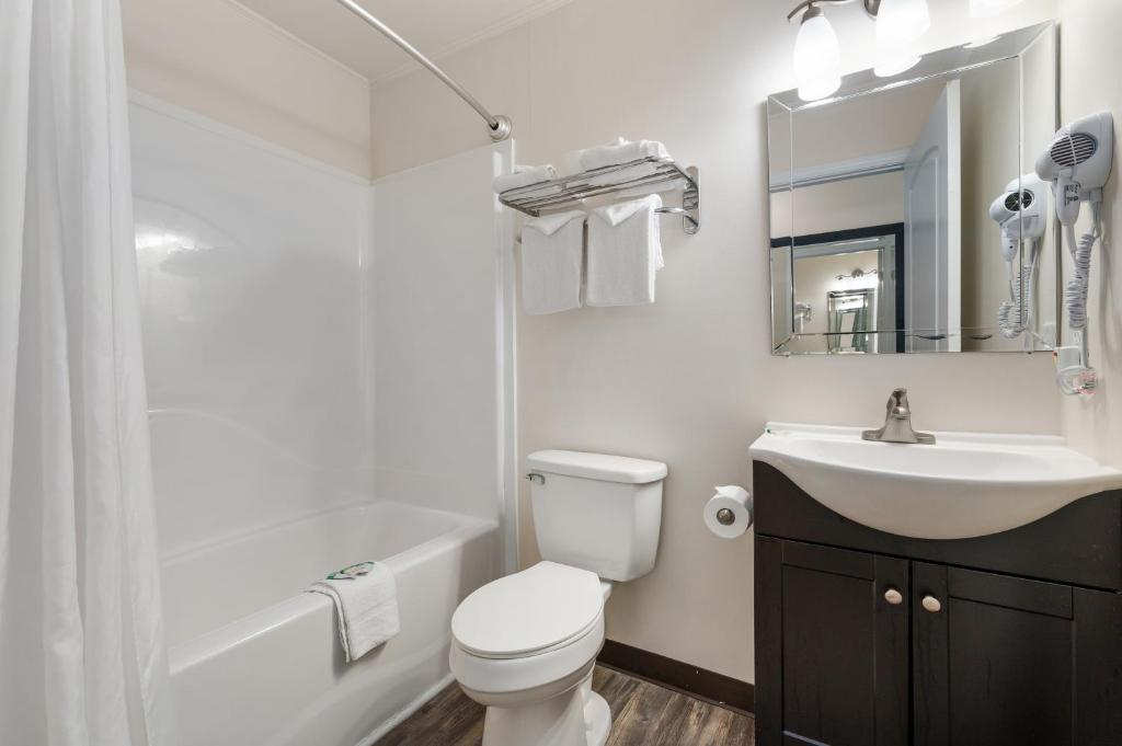 a bathroom with a sink and a toilet and a mirror at Beach Bum Inn in Ocean City