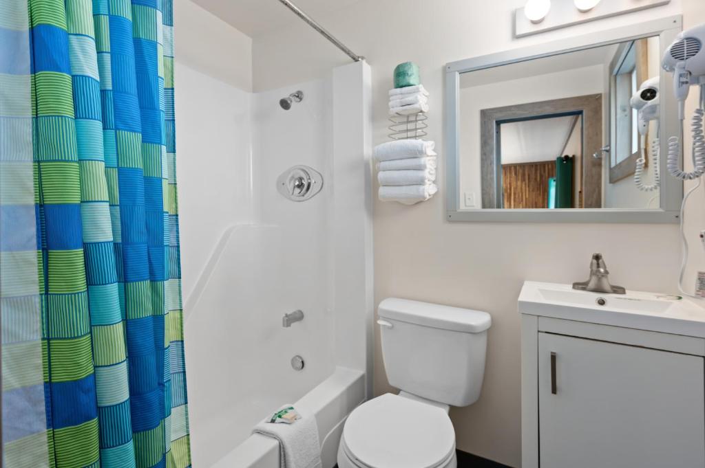 a bathroom with a toilet and a sink and a mirror at Beach Bum Inn in Ocean City
