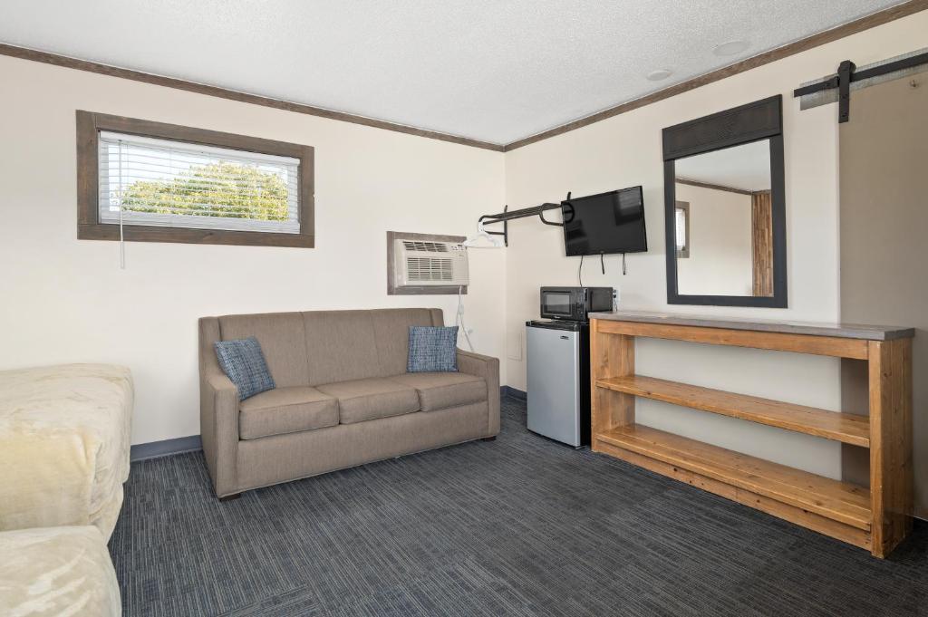 a living room with a couch and a chair and a mirror at Beach Bum Inn in Ocean City