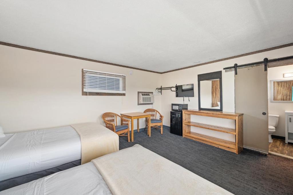 a hotel room with two beds and a table at Beach Bum Inn in Ocean City