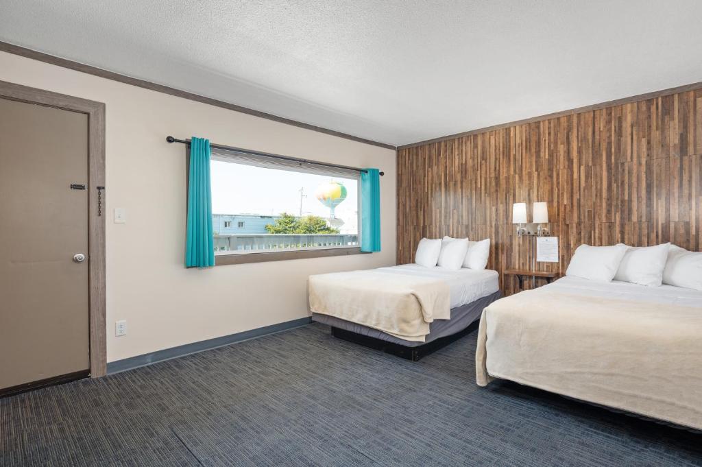 a hotel room with two beds and a window at Beach Bum Inn in Ocean City