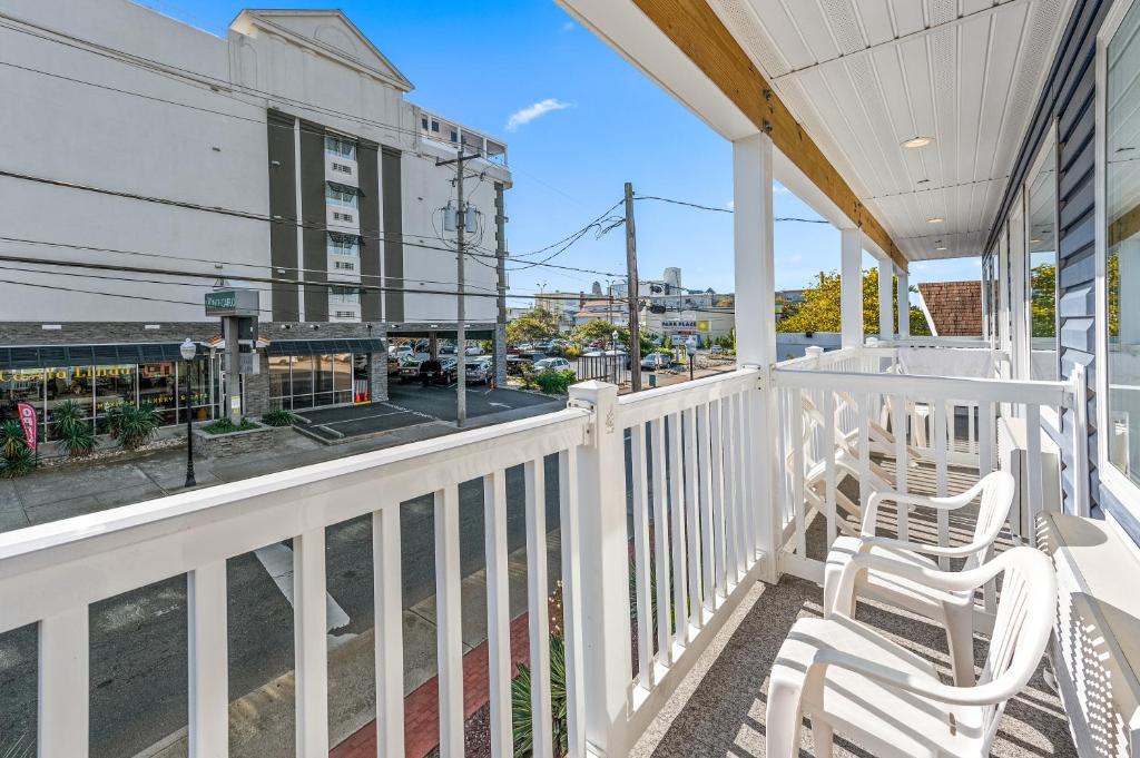 a balcony with two chairs and a view of a street at Beach Bum Inn in Ocean City
