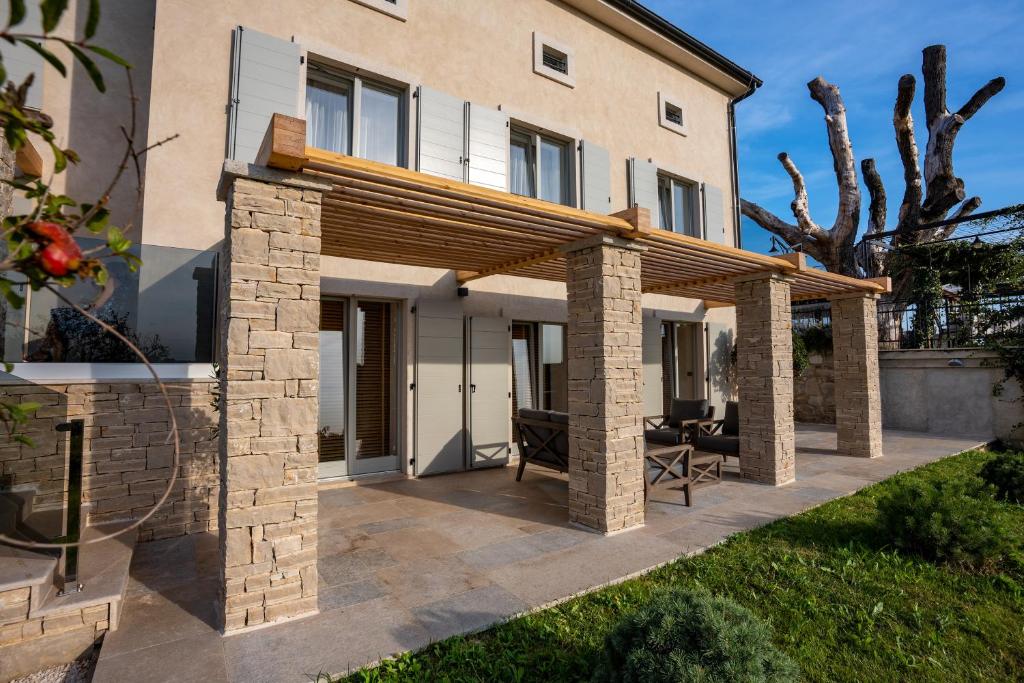 patio z drewnianą pergolą przed domem w obiekcie Restaurant & Villa Morgan w mieście Brtonigla