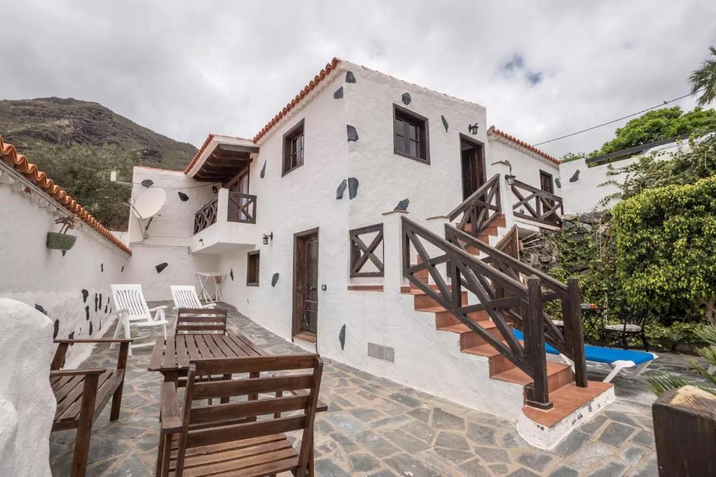 une maison blanche avec un escalier et une balustrade en bois dans l'établissement Casa Mercedes, Tamaimo, à Tamaimo