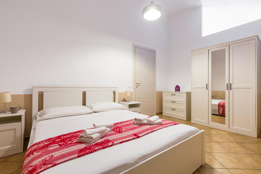 1 dormitorio con 1 cama blanca grande con sábanas rojas en La Marina, en Procida