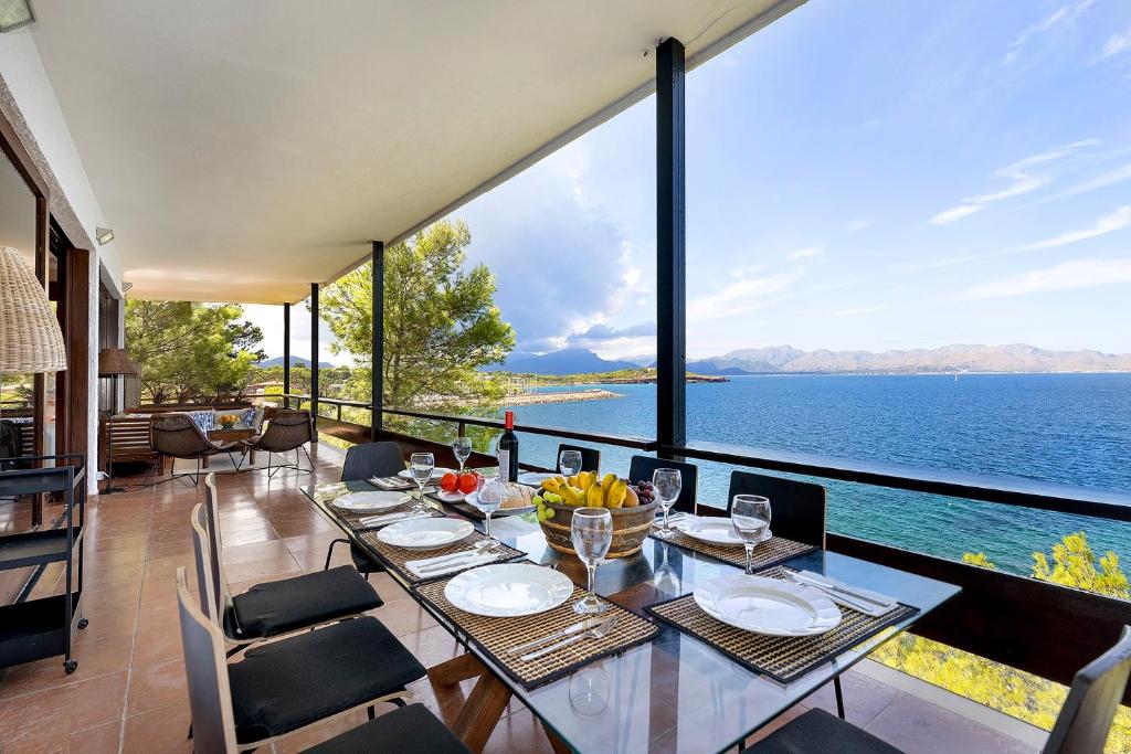 een eetkamer met een tafel en uitzicht op het water bij Es Balco, Villa over the mediterranean sea with private beach access in Cielo de Bonaire 