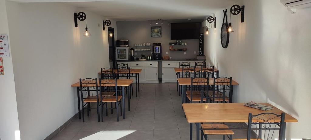 a restaurant with tables and chairs and a kitchen at Hôtel Le 15 Périgueux in Coulounieix-Chamiers