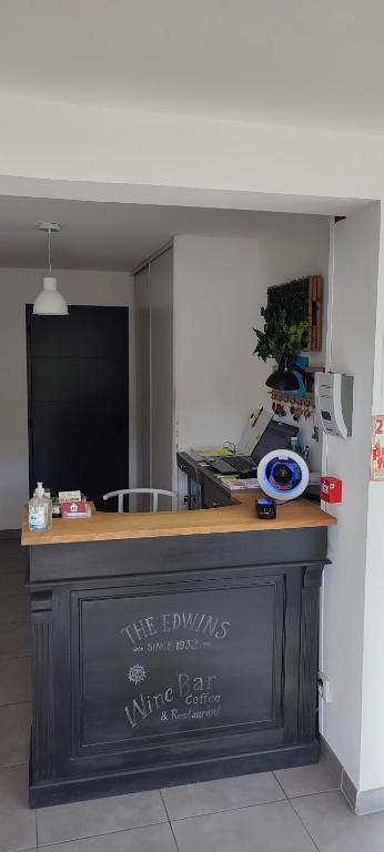 a bar in a room with a counter with writing on it at Hôtel Le 15 Périgueux in Coulounieix-Chamiers