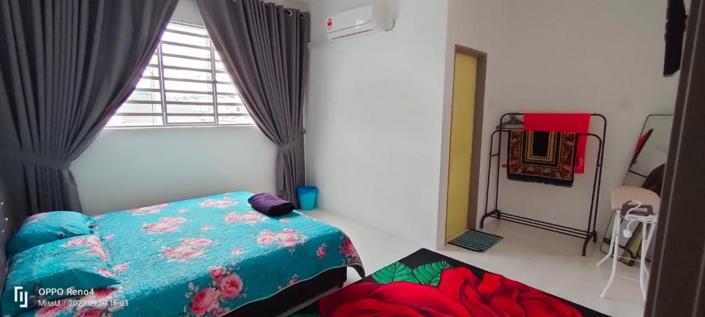 a small bedroom with a bed and a window at RAYYAN HOMESTAY SERI ISKANDAR PERAK in Kampong Bota Road