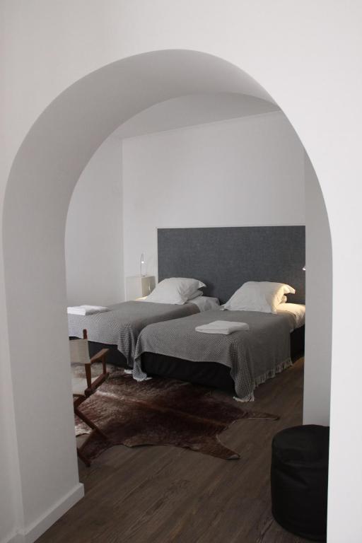 a bedroom with two beds and an archway at GALLE - Suite dos Infantes in Beja