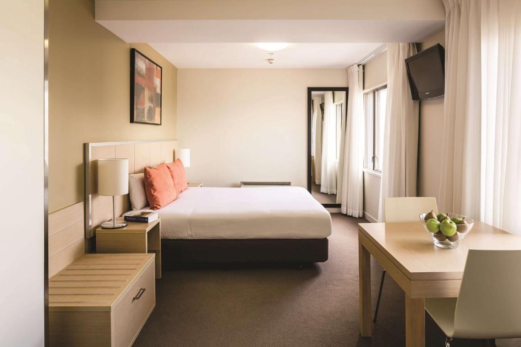 a hotel room with a bed and a desk at Travelodge Hotel Wellington in Wellington