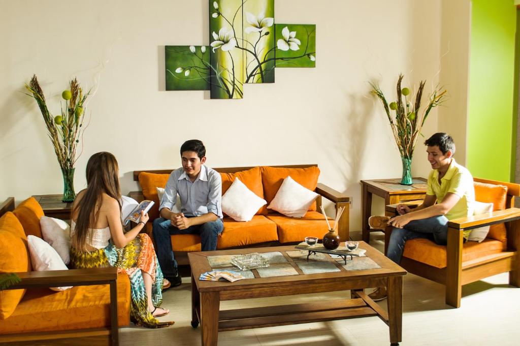 a group of three people sitting in a living room at Hotel Mitru - Tarija in Tarija