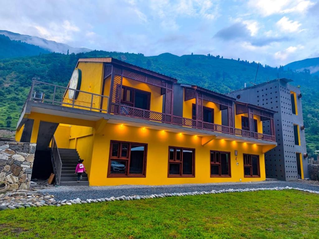 a yellow house with a balcony on top of it at Bela Resorts Naran in Nārān