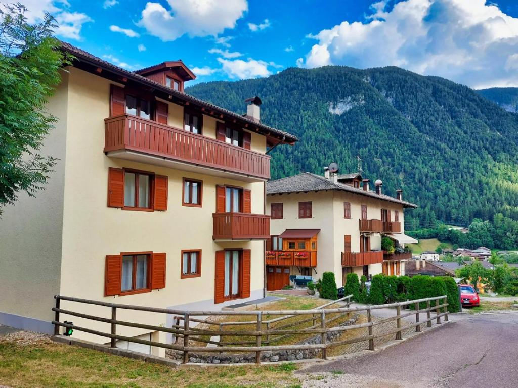 a building with a fence in front of a mountain at Casa Molini in Malè