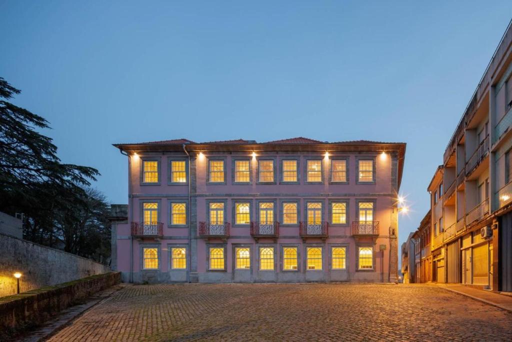 een groot gebouw met verlichte ramen aan een straat bij 4CITY FLAT CAMARÃO in Porto