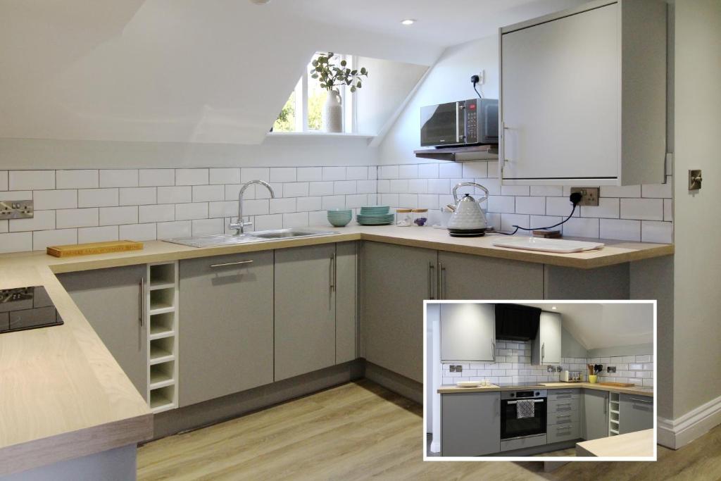 a kitchen with white cabinets and a sink at The White Hart Apartment Church View in Alton