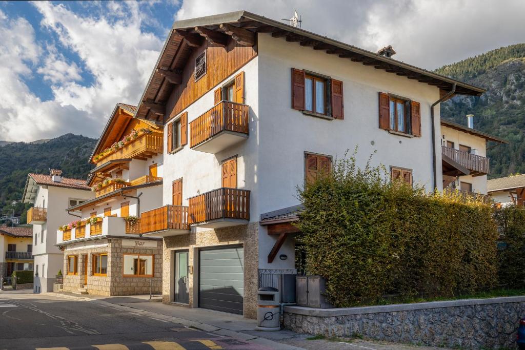 a white building with balconies on a street at [Presolana Home] relax con vista - SELF CHECK IN in Castione della Presolana