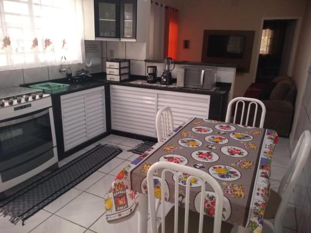 a kitchen with a table and chairs in a kitchen at Casa Pra temporada in Aparecida