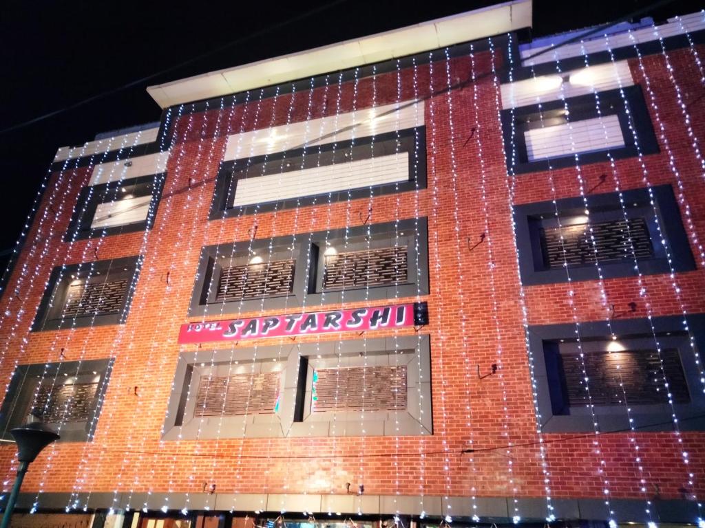 a red brick building with a sign on it at HOTEL SAPTARSHI in Bānkura