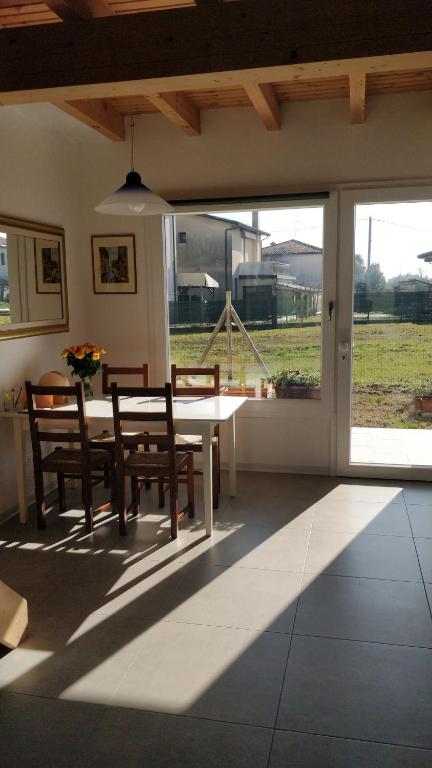 d'une salle à manger avec une table, des chaises et une fenêtre. dans l'établissement Porte di Venezia, Tessera Aeroporto, à Favaro Veneto
