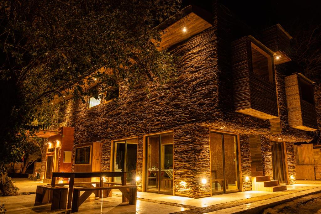 聖佩德羅·德·阿塔卡馬的住宿－Foresta Atacama Lodge，一座在晚上有桌子的建筑