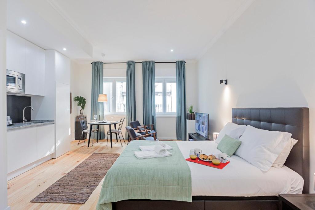een slaapkamer met een bed en een dienblad met fruit erop bij 150 Rivoli Apartments by LovelyStay in Porto