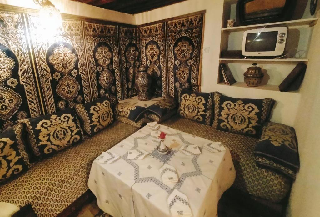 een kamer met een tafel en een tv. bij Riad dar Kirami in Fès