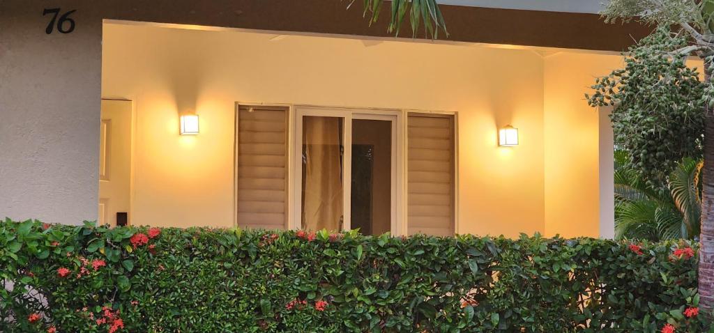 two lights on the side of a house with a hedge at PALMS ESCAPE - 3 BEDROOM VACATION HOME in Richmond