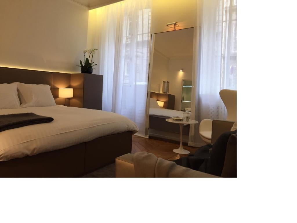 une chambre avec un lit, une chaise et un miroir dans l'établissement Cirque Deluxe Studio Apartment, à Paris