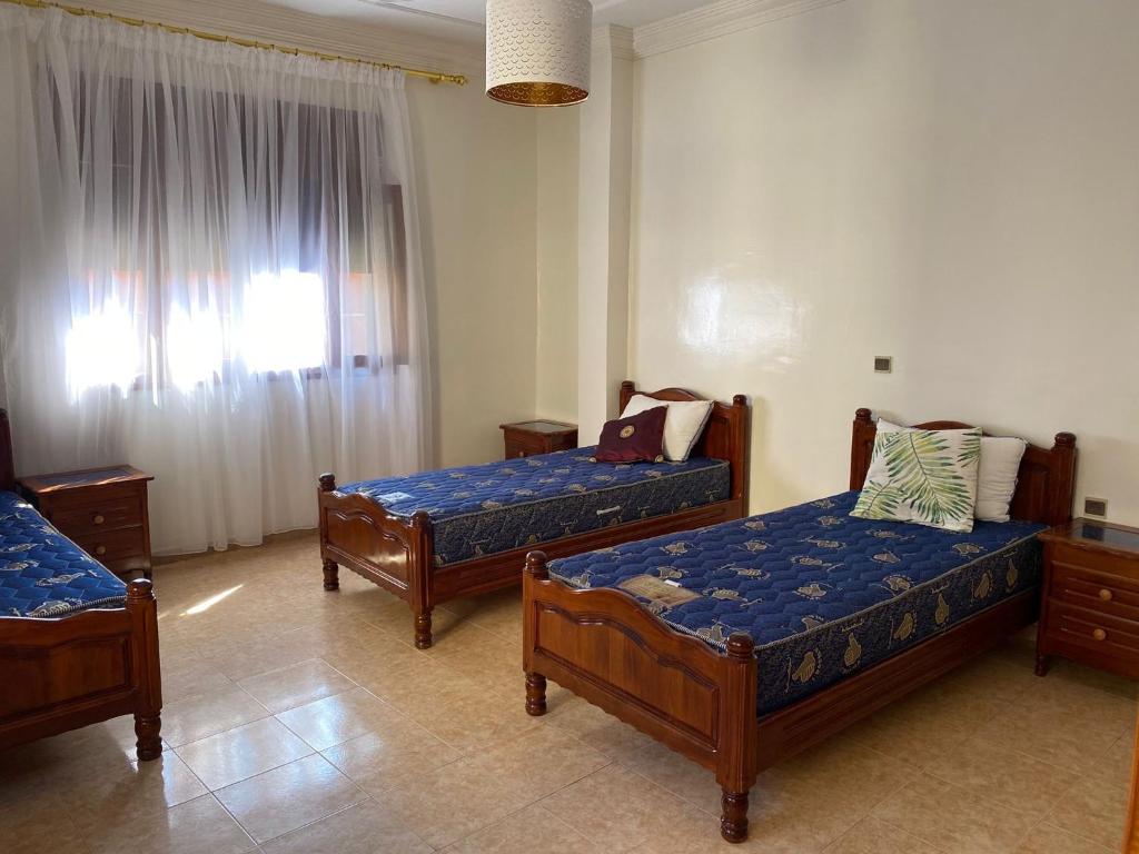 um quarto com 2 camas e uma janela em Appartement vue sur mer - Al Hoceima em Al Hoceïma