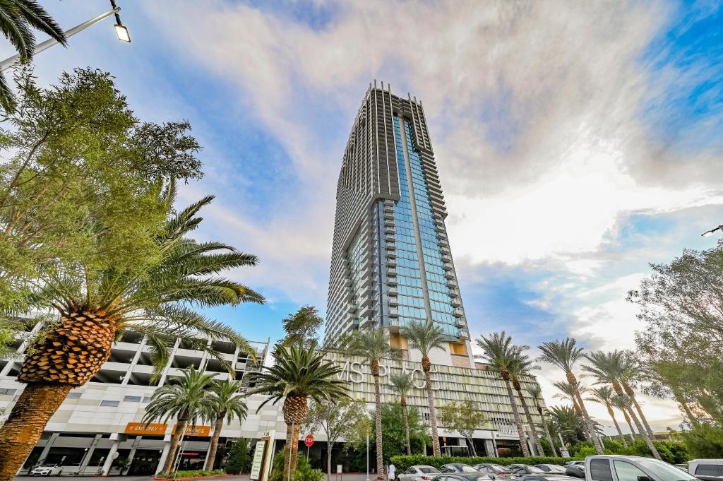 um edifício alto com palmeiras em frente em StripViewSuites Two-Bedroom Con-Joined Exclusive Condo em Las Vegas