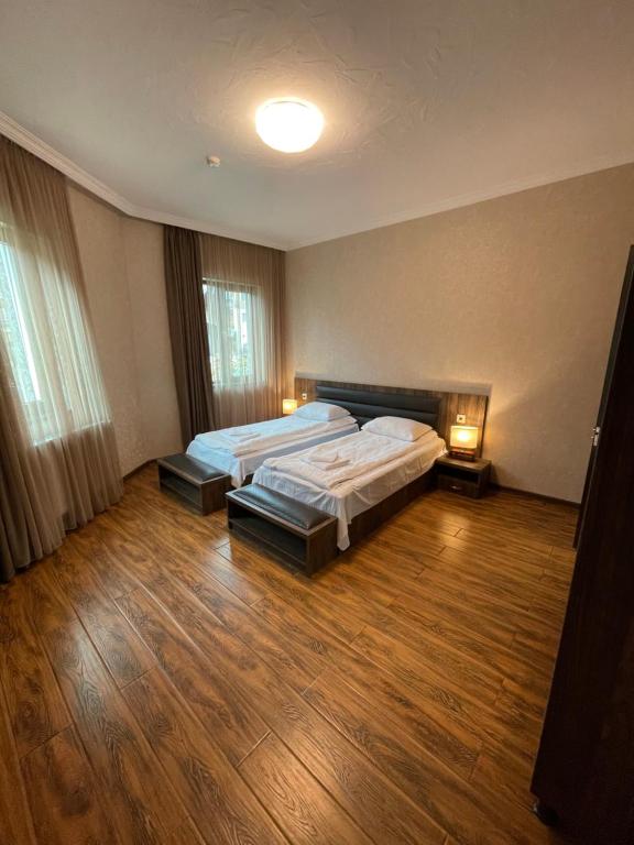 a large bedroom with two beds and two lamps at Hotel Elite House in Mestia