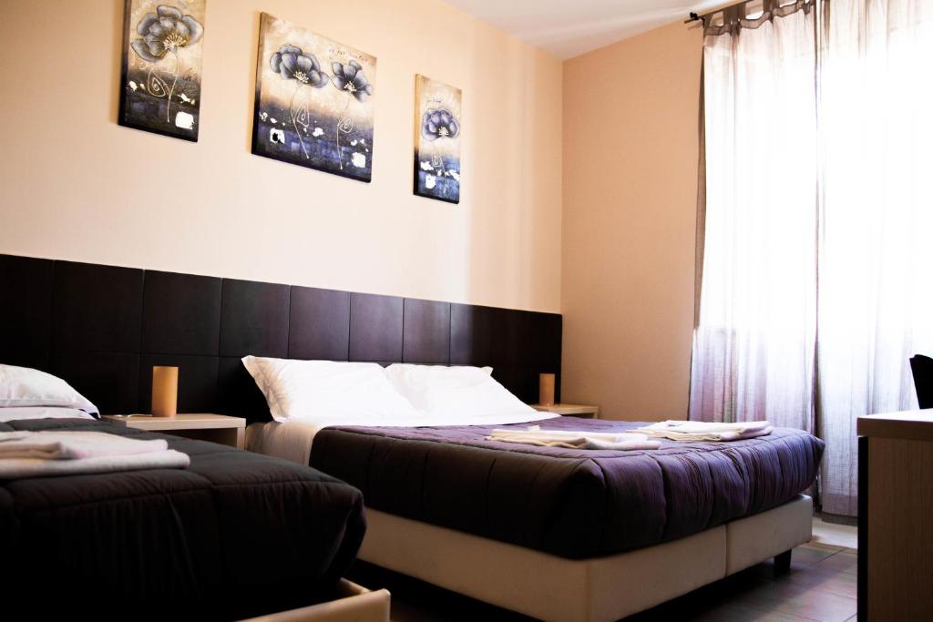 ローマにあるMosaic Central Guest Houseのベッドルーム1室(ベッド2台、窓付)