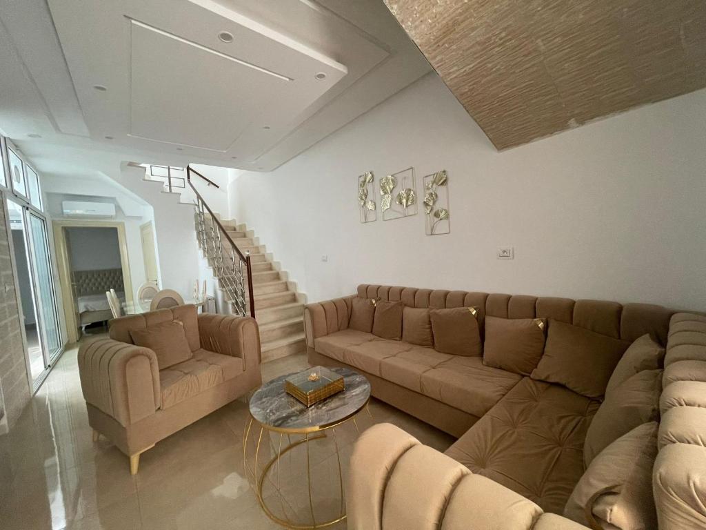 ein Wohnzimmer mit einem Sofa und einem Tisch in der Unterkunft La maison du Jasmin in Mahdia