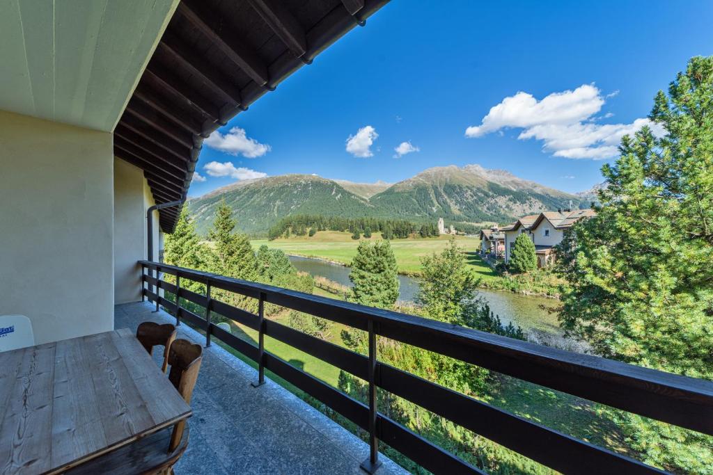 a balcony with a view of a river and mountains at Chesa Pradash 5 - Celerina in Celerina