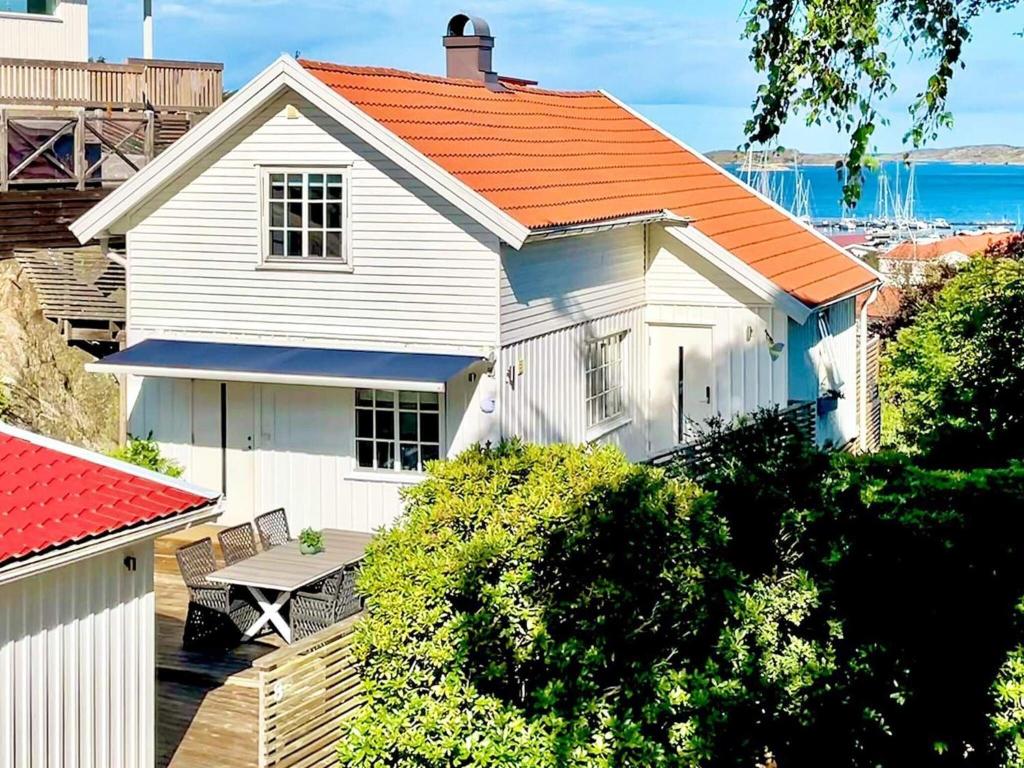 a white house with an orange roof and a table at 8 person holiday home in ELL S in Ellös