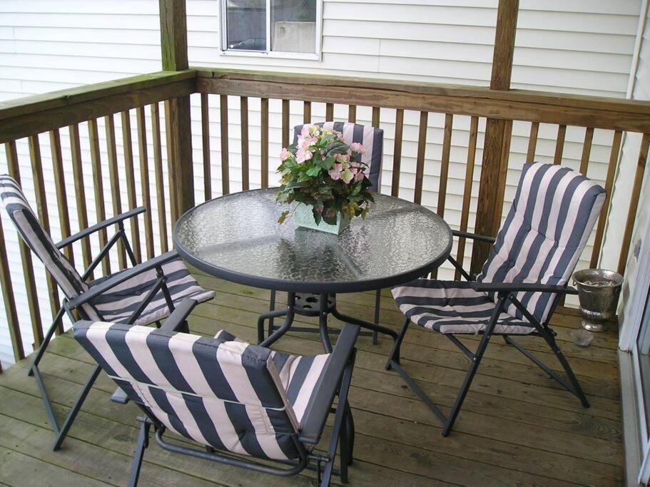 una mesa y sillas en un porche con una mesa y flores en 2 Bedroom Condo in Rehoboth Beach w/ New Bed en Rehoboth Beach