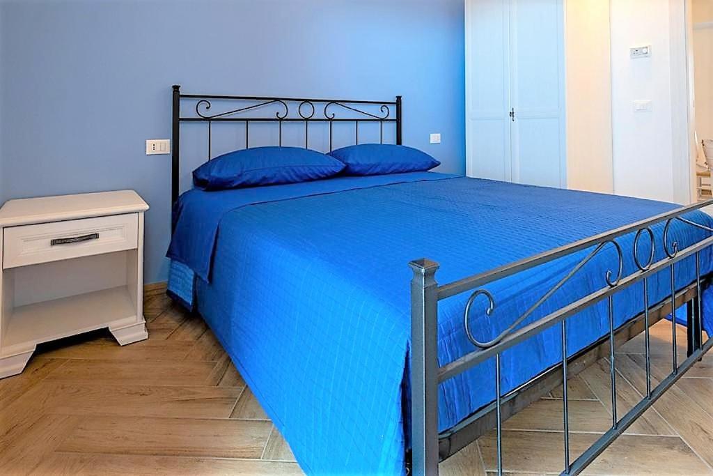 ein blaues Schlafzimmer mit einem blauen Bett und blauen Kissen in der Unterkunft IL MASCHERONE in Sepino
